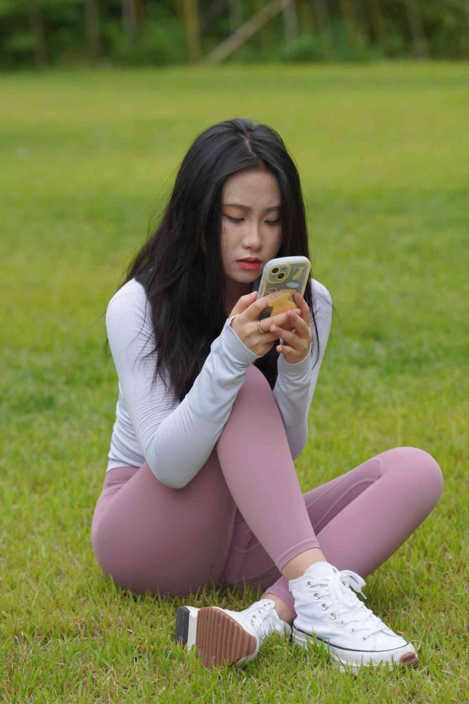 坐在草地玩手机的瑜伽姑娘【733P】04012-巴卡街拍